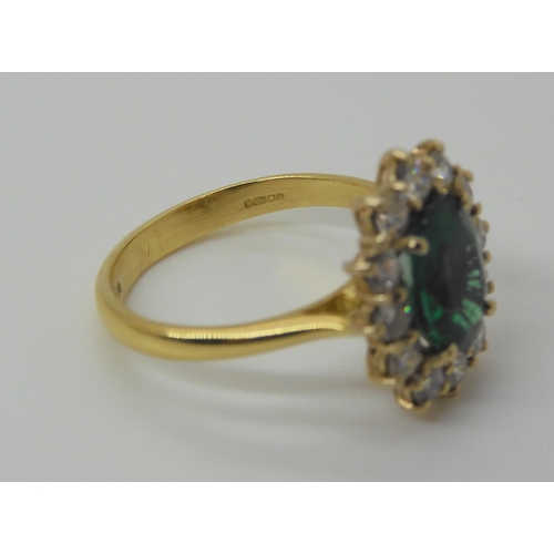 718 - An 18ct gold emerald and diamond cluster ring, set with a 8.6mm x 6.4mm x 3.8mm, oval emerald, furth... 