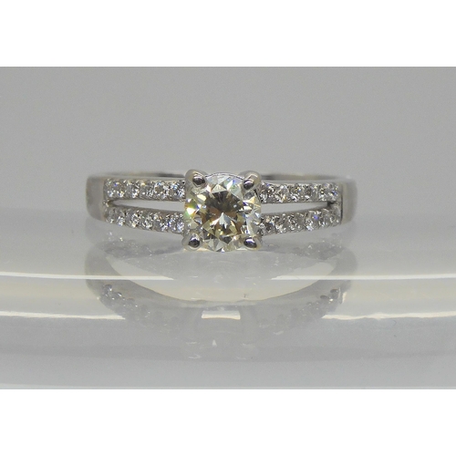 725 - An 18ct white gold diamond ring set with an estimated approx 0.50ct diamond with further diamonds to... 