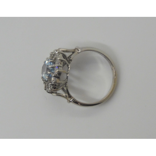 732 - An 18ct white gold aquamarine and diamond cluster with fleur de lys shoulders, the aquamarine measur... 
