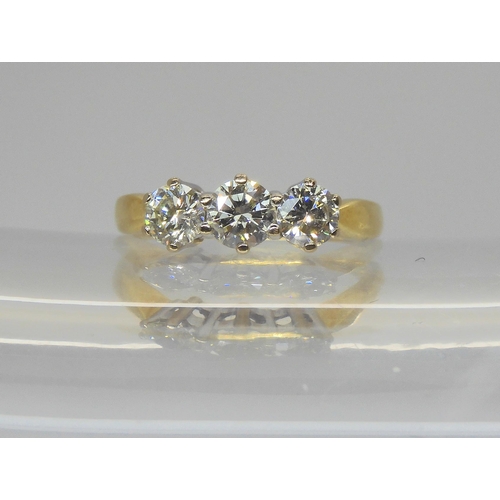743 - An 18ct gold three stone diamond ring, set throughout in yellow gold. The three diamonds together ar... 