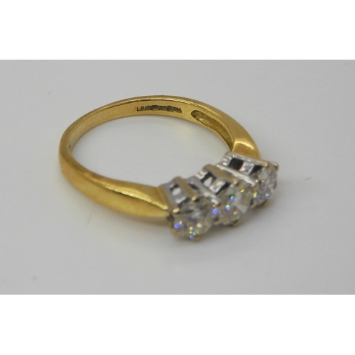 743 - An 18ct gold three stone diamond ring, set throughout in yellow gold. The three diamonds together ar... 