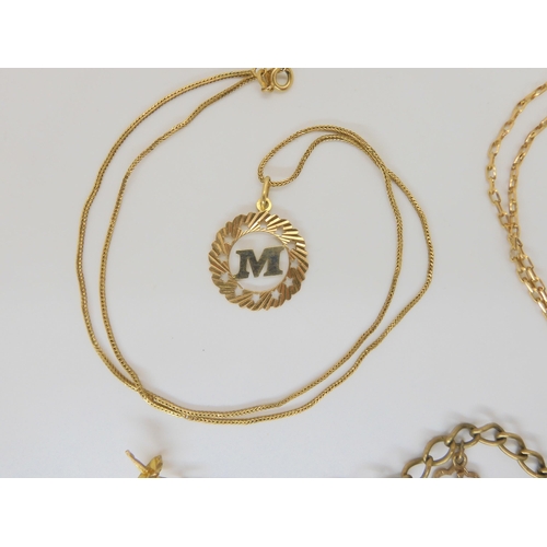 784 - A 9ct gold charm bracelet with seven charms, a 9ct Leo pendant on chain, and an 18ct gold M pendant ... 
