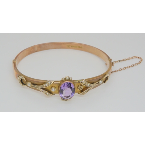 797 - A Victorian 9ct rose gold bangle, with central set amethyst surrounded by seed pearls, 9.1gms