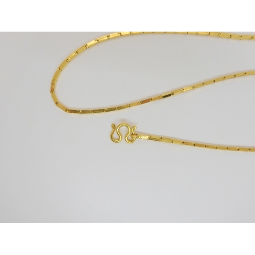 834 - A yellow metal neck chain with indistinct marks, 35cm long, with S scroll catch, 15.2gms