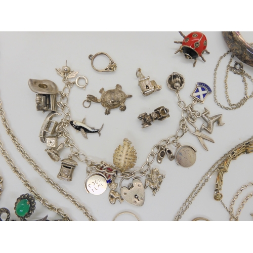 874 - A silver charm bracelet, with attached and loose, silver and white metal charms and other items