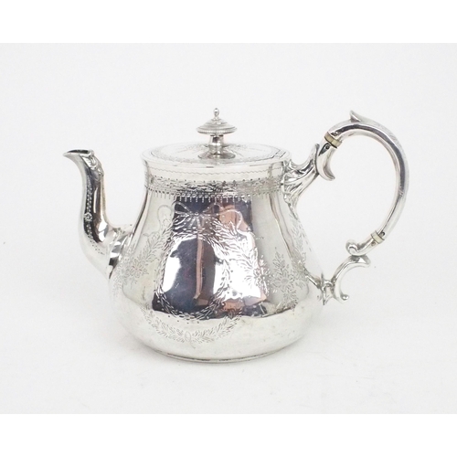 2458 - A VICTORIAN SILVER TEAPOTof swollen cylindrical form, the body with engraved floral decoration, the ... 