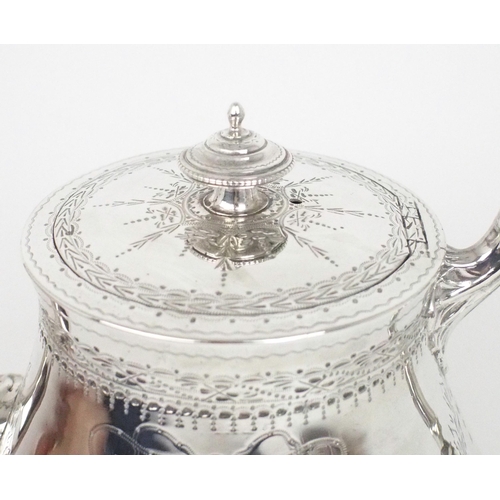 2458 - A VICTORIAN SILVER TEAPOTof swollen cylindrical form, the body with engraved floral decoration, the ... 