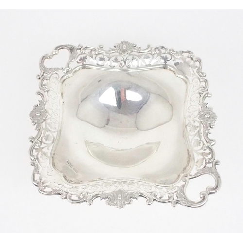 2470 - AN EDWARDIAN SILVER TAZZAof square form, with a cast openwork scrolling foliate rim, the two corners... 