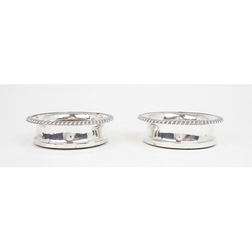 2481 - A MATCHED PAIR OF GEORGE IV SILVER WINE COASTERSwith gadrooned rims and turned wooden inserts, with ... 