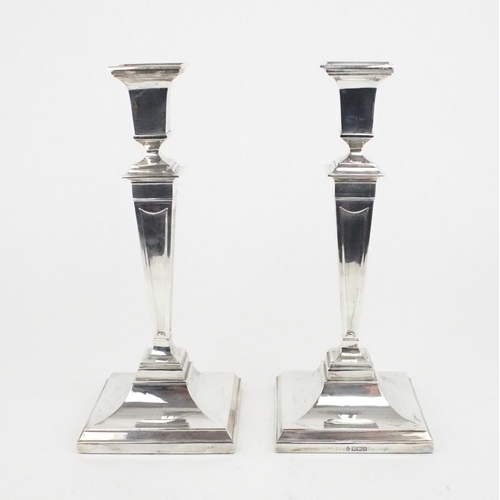 2489 - A PAIR OF EDWARDIAN SILVER CANDLESTICKSof tapering square form, on stepped sloping square bases,  ba... 