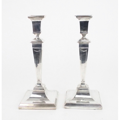 2489 - A PAIR OF EDWARDIAN SILVER CANDLESTICKSof tapering square form, on stepped sloping square bases,  ba... 