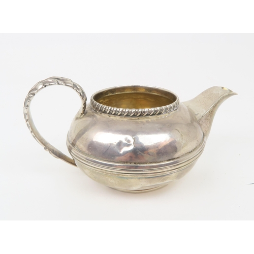 2494 - A GEORGE III SILVER CREAM JUGof teapot form, with central banding, a gadrooned rim and acanthus leaf... 