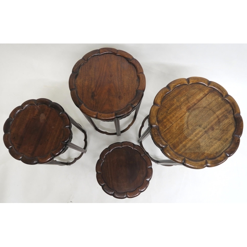 2014 - A 19TH CENTURY CHINESE HARDWOOD CIRCULAR NEST OF FOUR TABLESwith shaped circular tops over carved fl... 