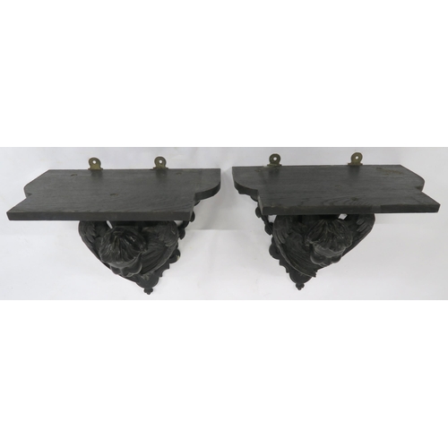 2046 - A PAIR OF 19TH CENTURY EBONISED WALL BRACKETSwith shaped moulded tops over carved cherubs heads flan... 