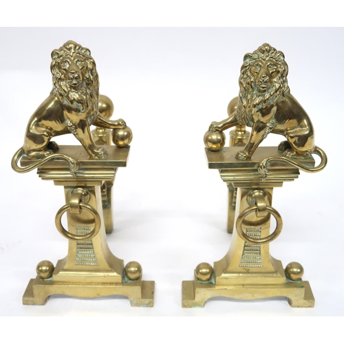 2052 - A PAIR OF EARLY 20TH CENTURY CAST BRASS FIRE DOGSmounted with figural lions, 46cm high x 23cm wide x... 