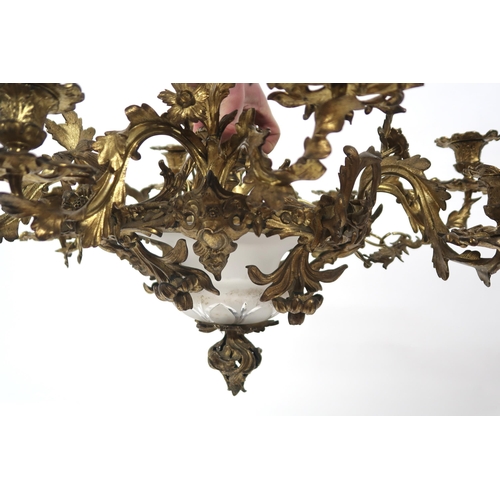 2064 - A REGENCY STYLE GILT METAL EIGHT BRANCH ROCOCO STYLE CANDELABRAwith central moulded frosted glass sh... 