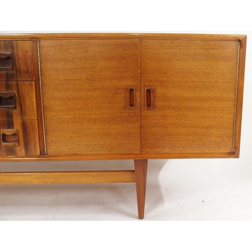 2105 - *WITHDRAWN* A MID 20TH CENTURY ROSEWOOD AND TEAK SIDEBOARDwith three rosewood veneered central drawe... 