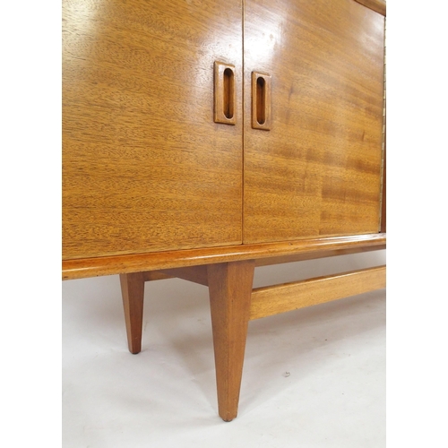 2105 - *WITHDRAWN* A MID 20TH CENTURY ROSEWOOD AND TEAK SIDEBOARDwith three rosewood veneered central drawe... 