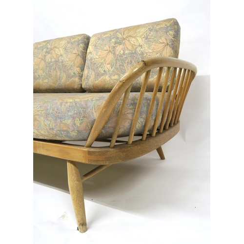 2111 - A MID 20TH CENTURY ELM AND BEECH FRAMED ERCOL DAY BEDwith floral upholstered cushions, 77cm high x 2... 