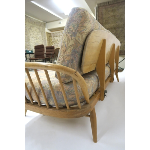 2111 - A MID 20TH CENTURY ELM AND BEECH FRAMED ERCOL DAY BEDwith floral upholstered cushions, 77cm high x 2... 