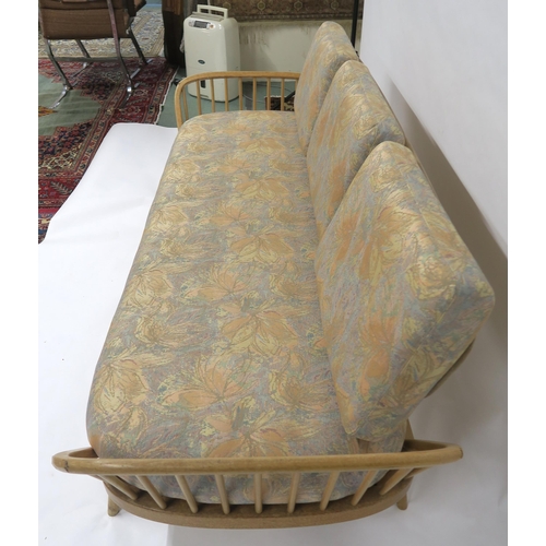 2111 - A MID 20TH CENTURY ELM AND BEECH FRAMED ERCOL DAY BEDwith floral upholstered cushions, 77cm high x 2... 