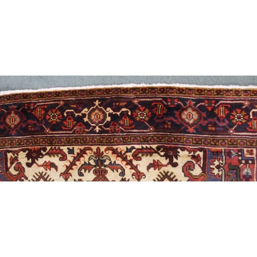 2130 - A CREAM AND TERRACOTTA GROUND HERIZ RUGwith central medallion, matching spandrels and dark blue bord... 