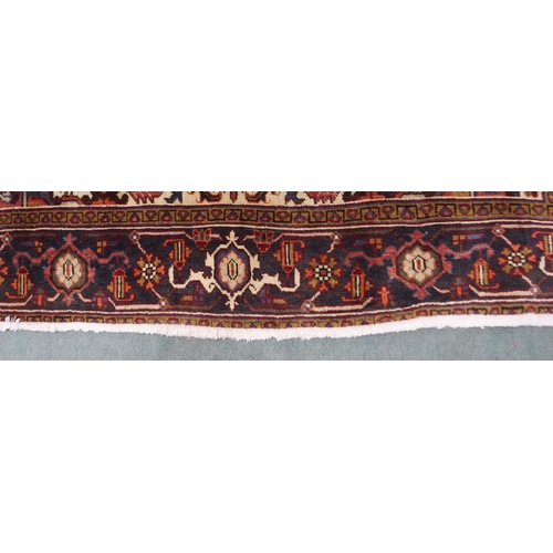 2130 - A CREAM AND TERRACOTTA GROUND HERIZ RUGwith central medallion, matching spandrels and dark blue bord... 