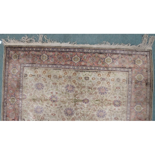 2131 - A CREAM GROUND SILK AND WOOL PERSIAN RUGwith floral foliate all-over design and pink borders, 185cm ... 