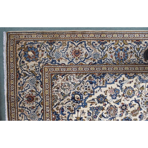 2133 - A CREAM GROUND KASHAN RUGwith blue diamond central medallion, matching spandrels and flower head bor... 