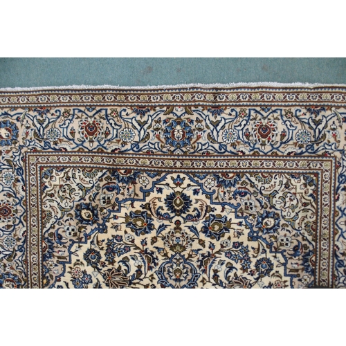 2133 - A CREAM GROUND KASHAN RUGwith blue diamond central medallion, matching spandrels and flower head bor... 