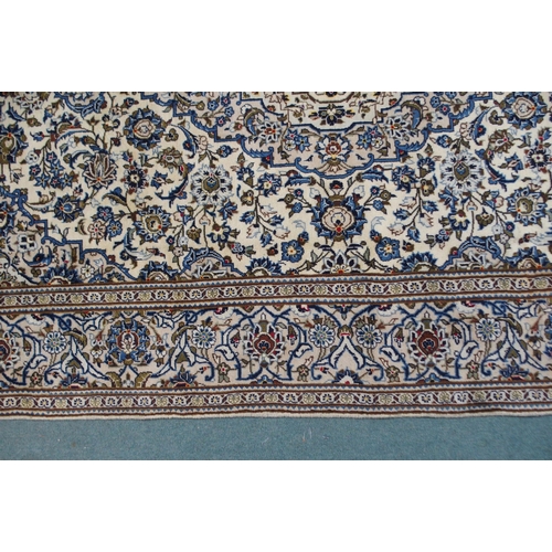 2133 - A CREAM GROUND KASHAN RUGwith blue diamond central medallion, matching spandrels and flower head bor... 