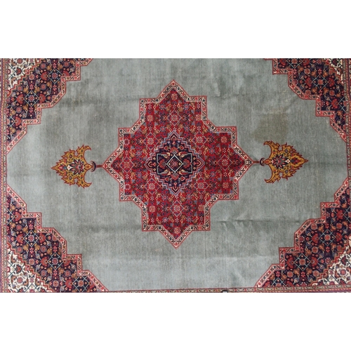 2134 - A GREEN GROUND TABRIZ RUGwith red geometric central medallion, dark blue and white spandrels and fol... 