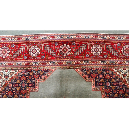 2134 - A GREEN GROUND TABRIZ RUGwith red geometric central medallion, dark blue and white spandrels and fol... 