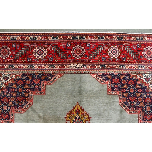 2134 - A GREEN GROUND TABRIZ RUGwith red geometric central medallion, dark blue and white spandrels and fol... 