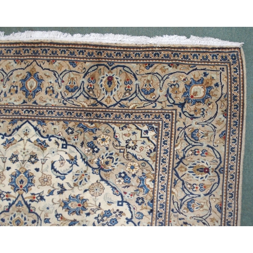 2135 - A CREAM GROUND KASHAN RUGwith diamond central medallion, matching spandrels and flower head borders,... 