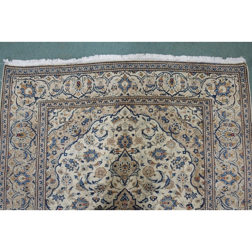 2135 - A CREAM GROUND KASHAN RUGwith diamond central medallion, matching spandrels and flower head borders,... 