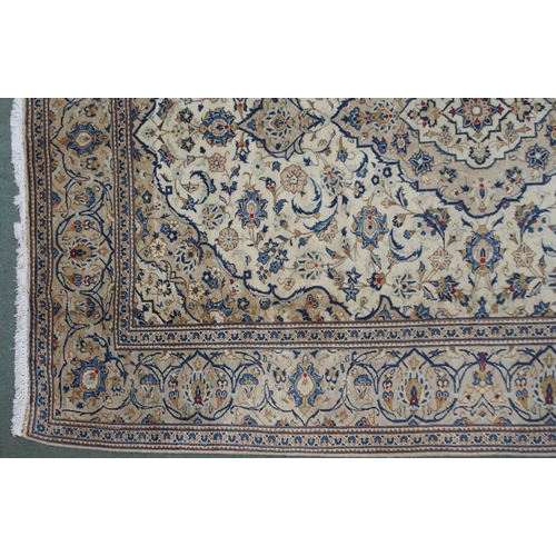 2135 - A CREAM GROUND KASHAN RUGwith diamond central medallion, matching spandrels and flower head borders,... 