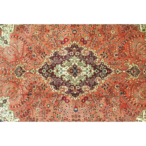 2137 - A TERRACOTTA GROUND TABRIZ RUGwith red and cream central medallion, cream and dark blue spandrels an... 