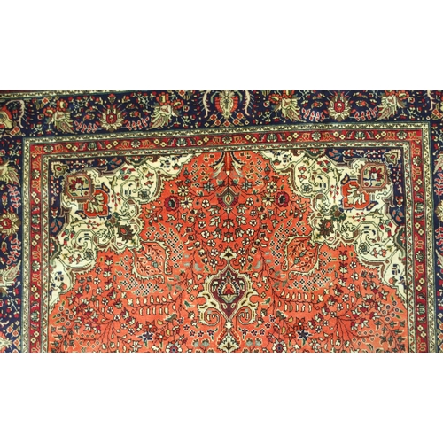 2137 - A TERRACOTTA GROUND TABRIZ RUGwith red and cream central medallion, cream and dark blue spandrels an... 