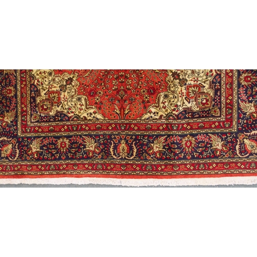 2137 - A TERRACOTTA GROUND TABRIZ RUGwith red and cream central medallion, cream and dark blue spandrels an... 