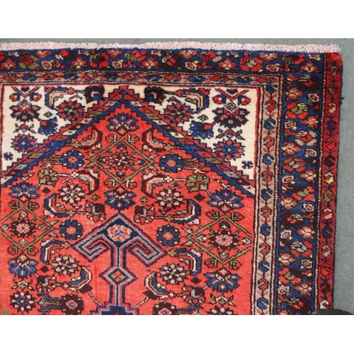 2138 - A TERRACOTTA GROUND HAMADAN RUGwith dark blue central medallion, cream spandrels and blue floral bor... 