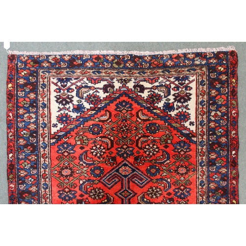 2138 - A TERRACOTTA GROUND HAMADAN RUGwith dark blue central medallion, cream spandrels and blue floral bor... 