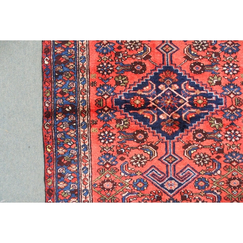 2138 - A TERRACOTTA GROUND HAMADAN RUGwith dark blue central medallion, cream spandrels and blue floral bor... 