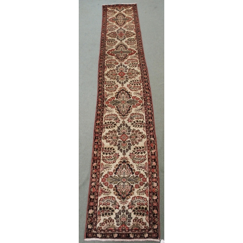 2139 - A CREAM GROUND HAMADAN RUNNERwith seven floral medallions and dark blue floral border, 459cm long x ... 