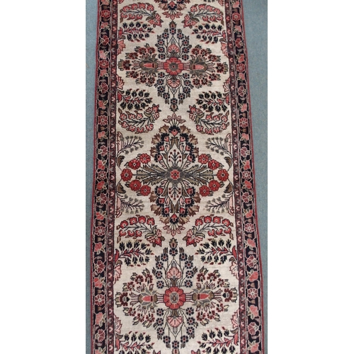 2139 - A CREAM GROUND HAMADAN RUNNERwith seven floral medallions and dark blue floral border, 459cm long x ... 