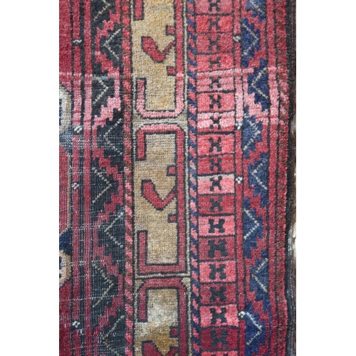 2145 - A RED GROUND CAUCASIAN KAZAK RUGwith three geometric medallions and geometric multicoloured border, ... 