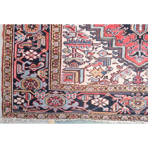 2147 - A RED GROUND KAZAK RUGwith dark blue geometric central medallion, off white spandrels and geometric ... 