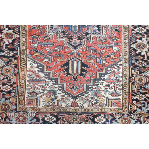 2147 - A RED GROUND KAZAK RUGwith dark blue geometric central medallion, off white spandrels and geometric ... 