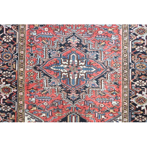 2147 - A RED GROUND KAZAK RUGwith dark blue geometric central medallion, off white spandrels and geometric ... 