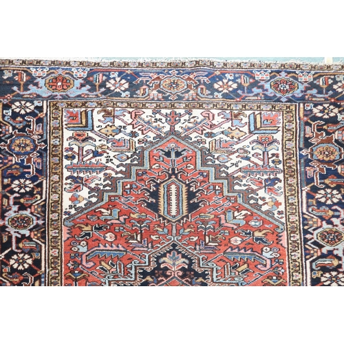 2147 - A RED GROUND KAZAK RUGwith dark blue geometric central medallion, off white spandrels and geometric ... 